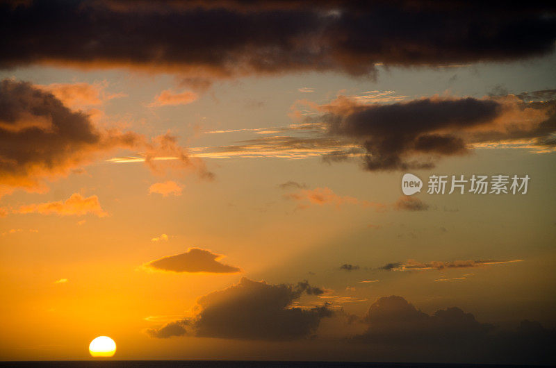 太阳穿过云层，天空呈暗黄色/橙色